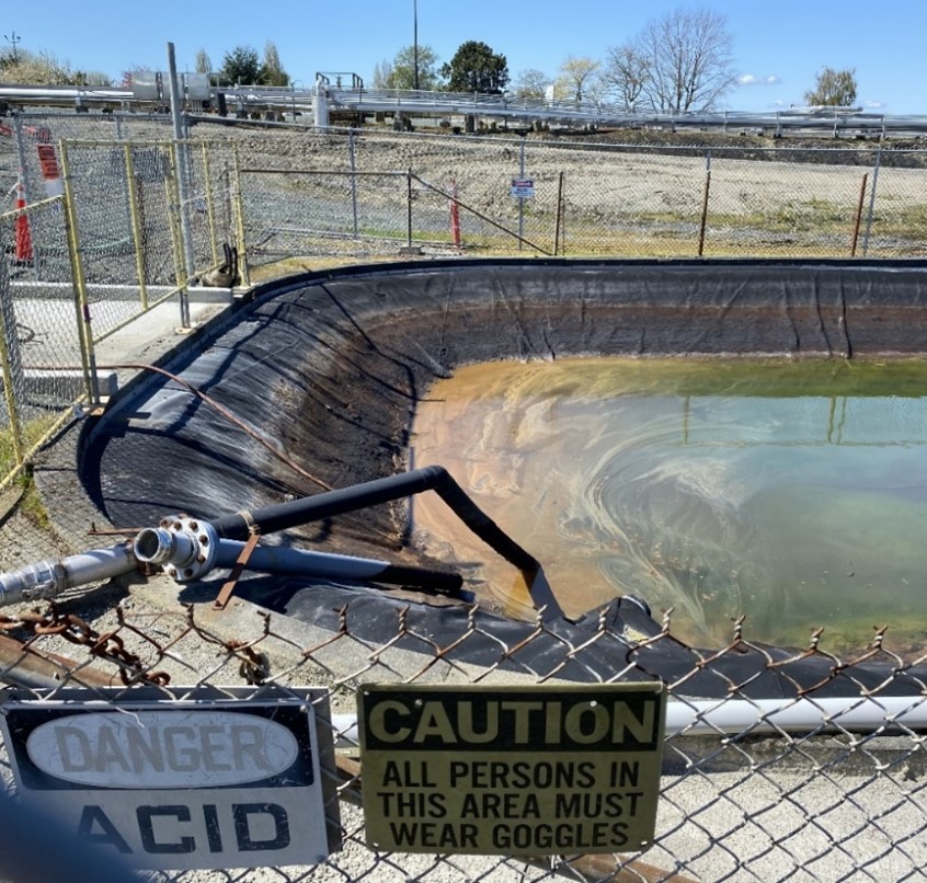 Portion of an artificial pond lined with plastic and partially filled with liquid.